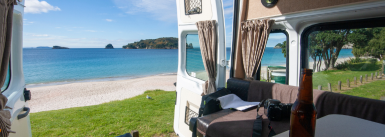 Campervan vor Strand und Meer.